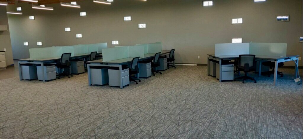 Open-plan benching workstations with glass divider screens and mobile pedestal files