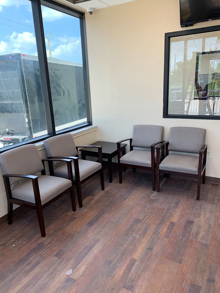 Waiting room with upholstered wood-frame guest chairs and a corner end table