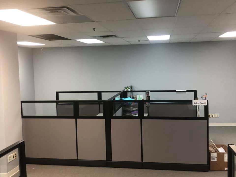 Gray cubicle workstations with glass topper panels in an open office